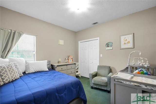 carpeted bedroom featuring a closet and a textured ceiling