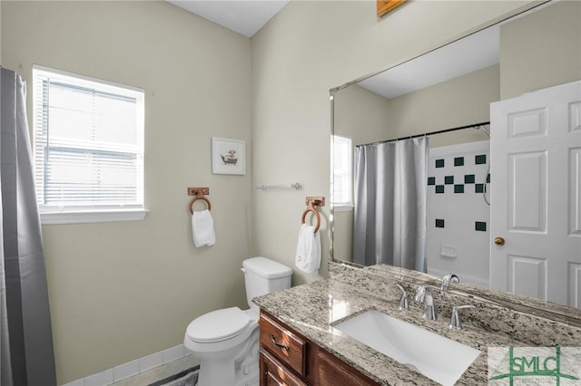 bathroom featuring a shower with shower curtain, vanity, and toilet