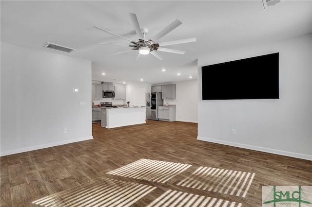 unfurnished living room with dark hardwood / wood-style floors and ceiling fan