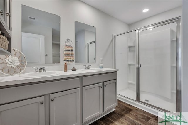 bathroom featuring hardwood / wood-style floors, vanity, and a shower with door