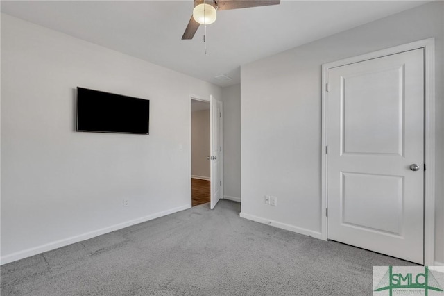 unfurnished bedroom featuring ceiling fan and light carpet