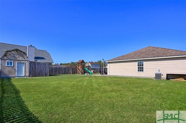 view of yard with a playground, central AC, and a storage shed