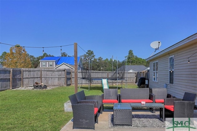 view of yard featuring a patio, a trampoline, and an outdoor living space with a fire pit