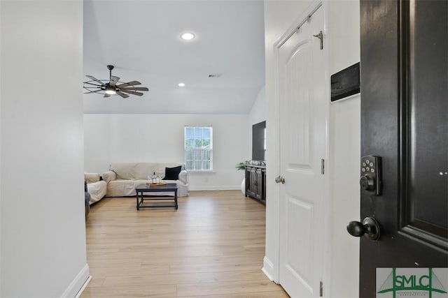 living room with light wood-type flooring, vaulted ceiling, and ceiling fan