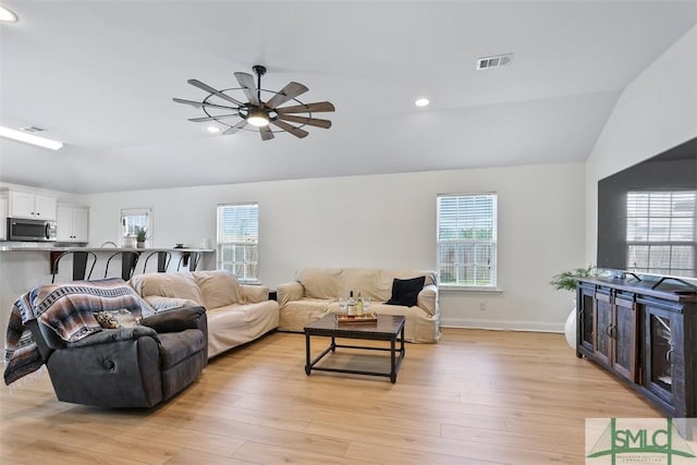 living room with light hardwood / wood-style floors, ceiling fan, and lofted ceiling