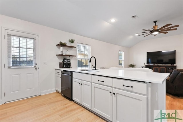 kitchen with sink, light hardwood / wood-style flooring, kitchen peninsula, dishwashing machine, and white cabinets