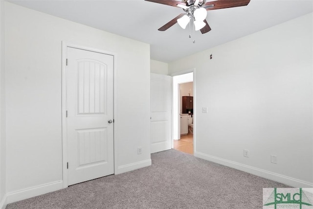 unfurnished bedroom with ceiling fan, light colored carpet, and a closet