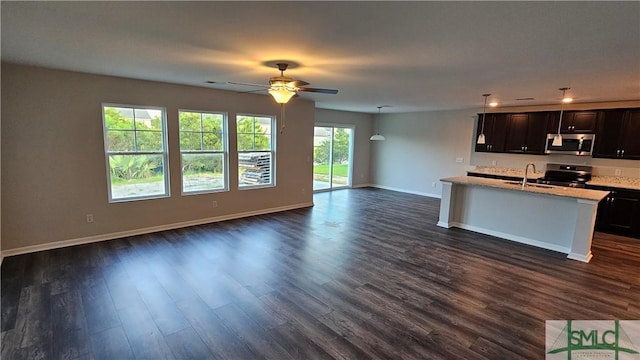 kitchen featuring ceiling fan, sink, stainless steel appliances, light stone counters, and dark hardwood / wood-style flooring