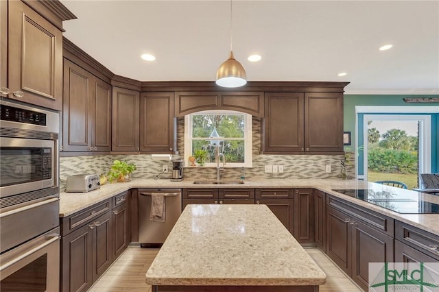 kitchen with light stone countertops, pendant lighting, appliances with stainless steel finishes, and sink