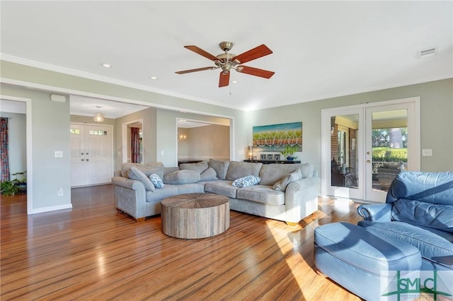 living room featuring hardwood / wood-style floors, ceiling fan, ornamental molding, and french doors