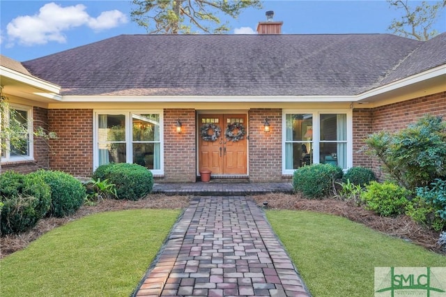 view of exterior entry featuring a yard