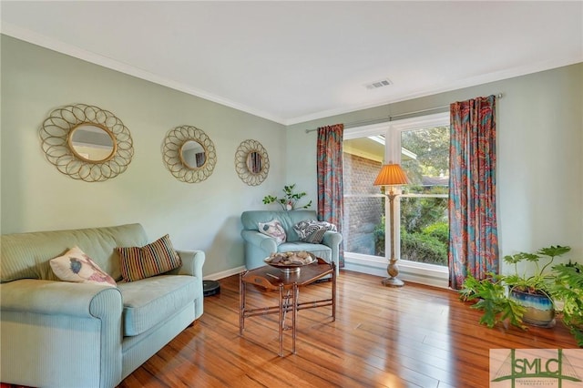 living room with wood-type flooring and crown molding