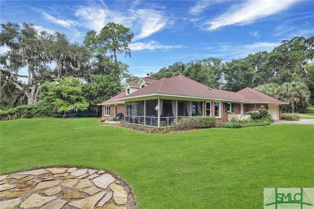 back of property with a yard and a sunroom