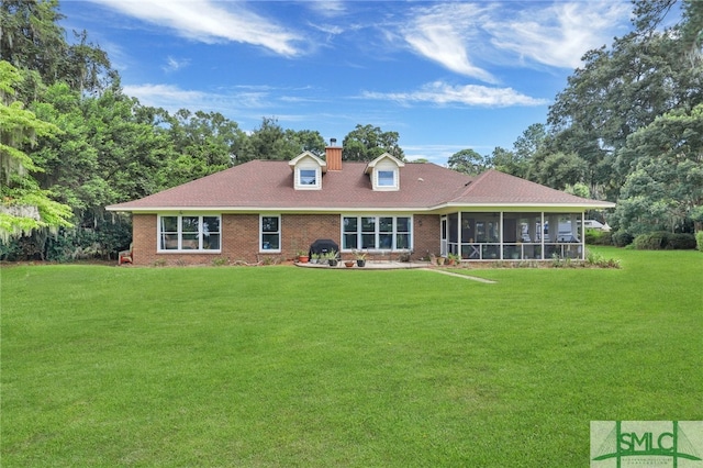 rear view of house featuring a sunroom and a lawn