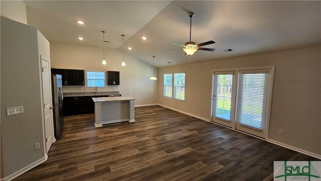 kitchen featuring stainless steel fridge, ceiling fan, decorative light fixtures, a center island, and dark hardwood / wood-style floors