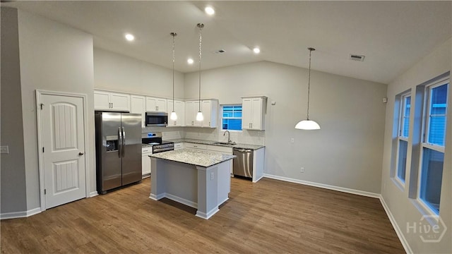 83 Marsh Salt Ln, Port Wentworth, GA 31407 - kitchen featuring appliances with stainless steel finishes, high vaulted ceiling, a kitchen island, white cabinets, and dark wood-style floors