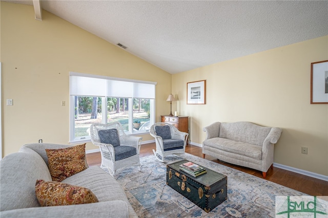 living room featuring a textured ceiling, hardwood / wood-style flooring, and vaulted ceiling