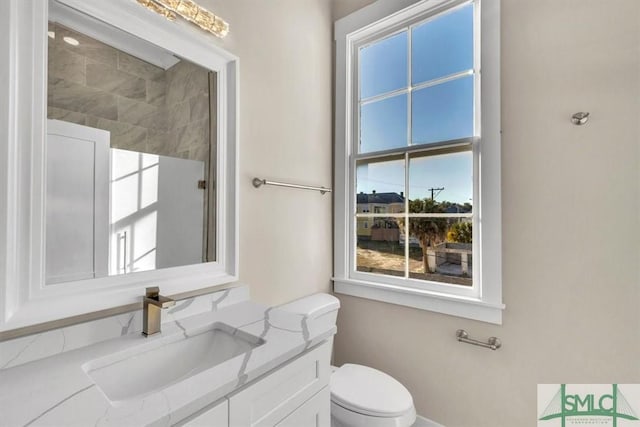 bathroom with vanity, toilet, and walk in shower