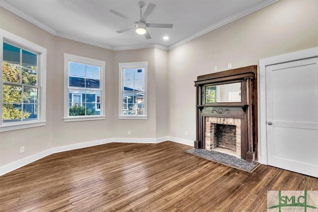 unfurnished living room featuring hardwood / wood-style flooring, ceiling fan, ornamental molding, and a brick fireplace