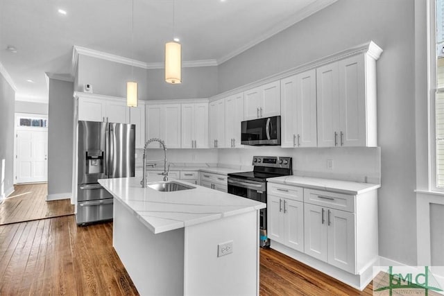 kitchen featuring appliances with stainless steel finishes, a kitchen island with sink, sink, white cabinetry, and hanging light fixtures