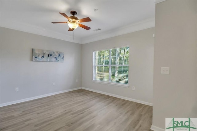 empty room with ceiling fan, light wood-type flooring, and crown molding