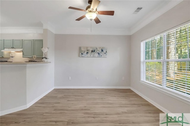 interior space with ceiling fan, crown molding, and light wood-type flooring