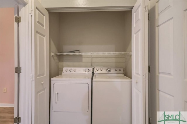 clothes washing area with hardwood / wood-style floors and independent washer and dryer