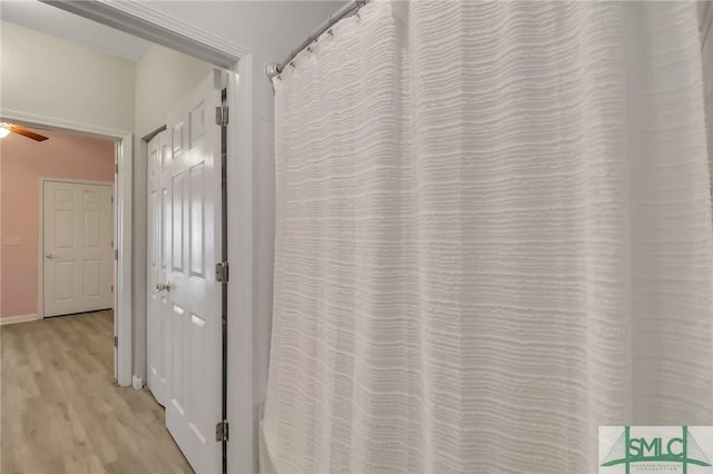 bathroom with ceiling fan and hardwood / wood-style floors