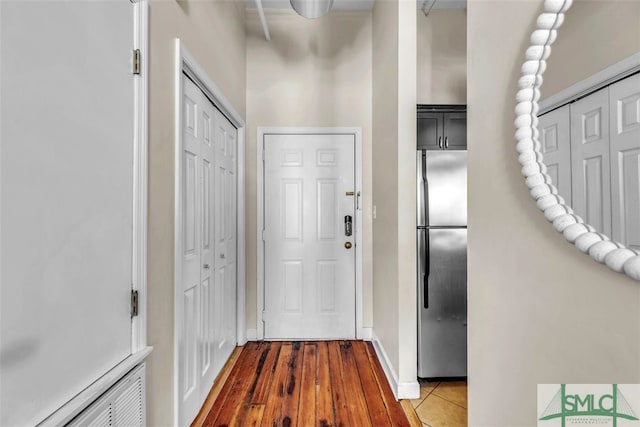 doorway to outside featuring wood-type flooring and a high ceiling