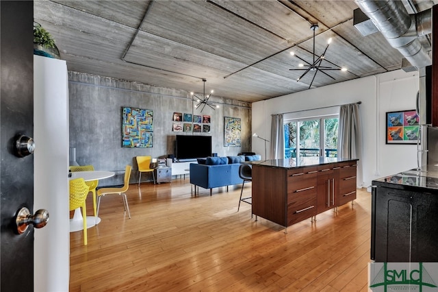 kitchen featuring a kitchen bar, light wood-type flooring, and an inviting chandelier