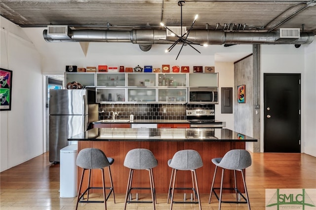 kitchen with decorative backsplash, a breakfast bar, a center island, and stainless steel appliances