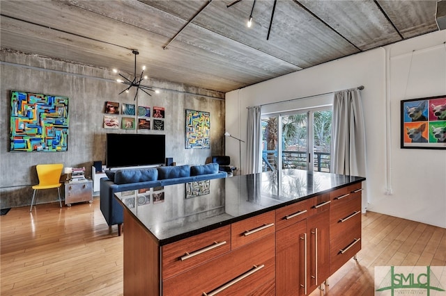 kitchen featuring light wood-type flooring, a kitchen island, and an inviting chandelier