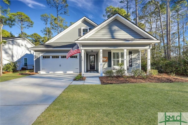 view of front facade with covered porch, a garage, and a front lawn