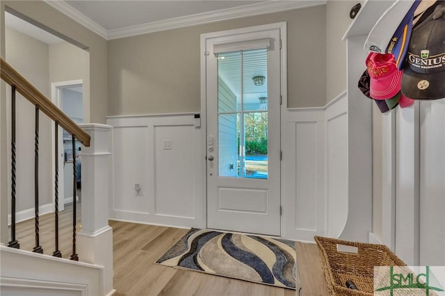 entryway with light wood-type flooring and ornamental molding