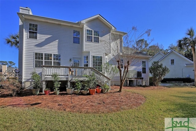 back of house featuring a yard and a wooden deck