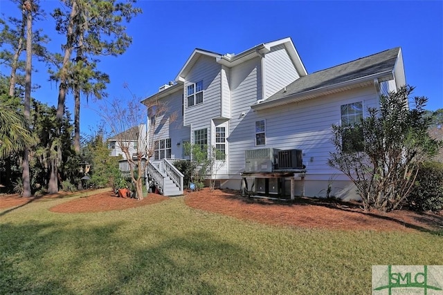 back of house featuring a yard and central air condition unit