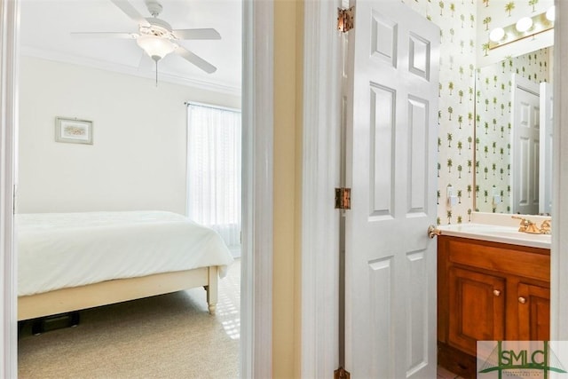 bathroom featuring vanity, crown molding, and ceiling fan