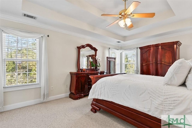 bedroom featuring crown molding, a tray ceiling, and light colored carpet