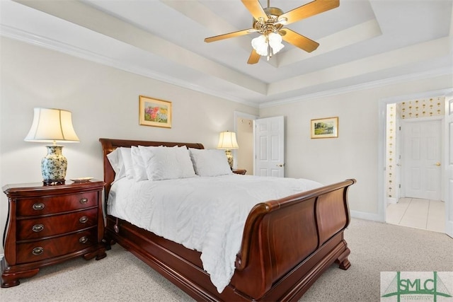 carpeted bedroom featuring a tray ceiling, crown molding, and ceiling fan