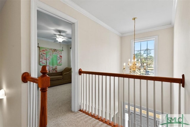 hall featuring carpet, a chandelier, and ornamental molding