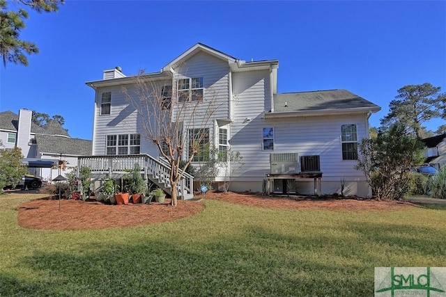 rear view of property featuring a yard, a deck, and central AC unit