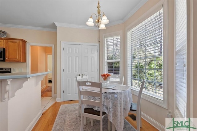 dining space featuring light hardwood / wood-style floors, crown molding, and a wealth of natural light