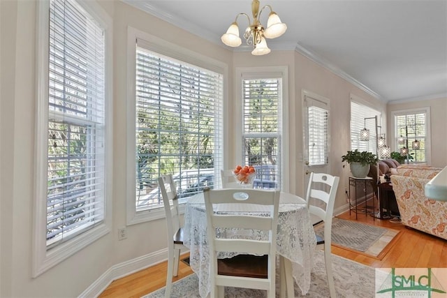 dining area featuring a notable chandelier, hardwood / wood-style flooring, and ornamental molding