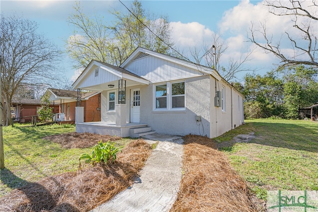 bungalow featuring a porch and a front lawn