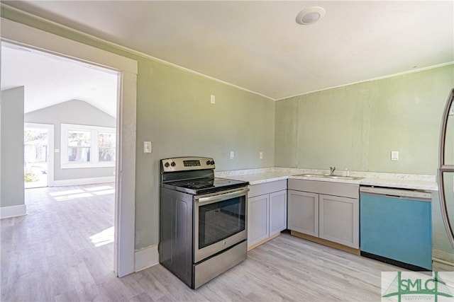 kitchen featuring appliances with stainless steel finishes, vaulted ceiling, sink, light hardwood / wood-style flooring, and gray cabinets