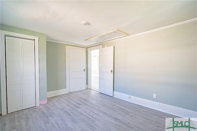 unfurnished bedroom with wood-type flooring, a closet, and ornamental molding