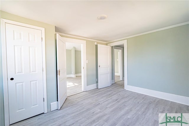 unfurnished bedroom featuring a closet, ornamental molding, and light hardwood / wood-style flooring