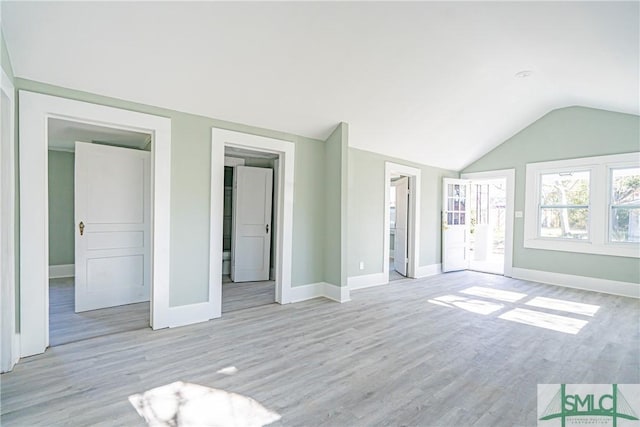 unfurnished living room with light hardwood / wood-style floors and lofted ceiling