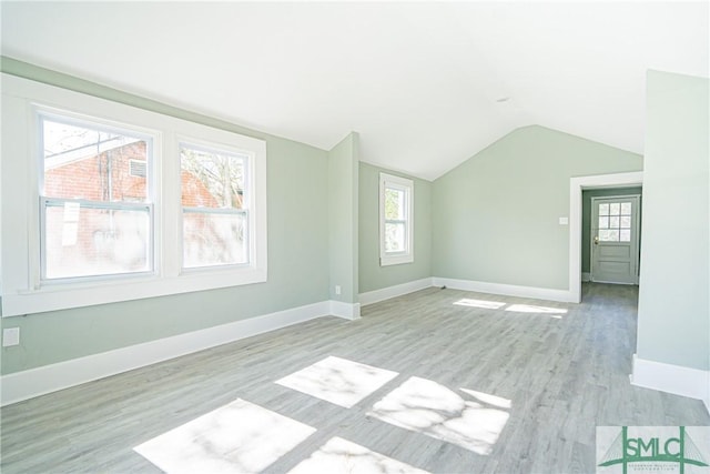 unfurnished room with light hardwood / wood-style flooring and lofted ceiling