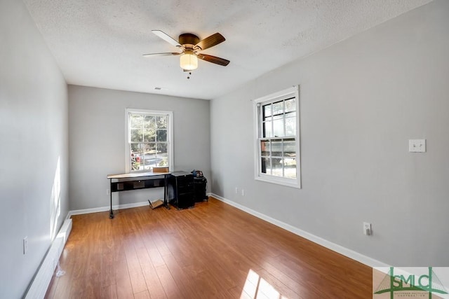 spare room featuring wood-type flooring, a textured ceiling, and ceiling fan